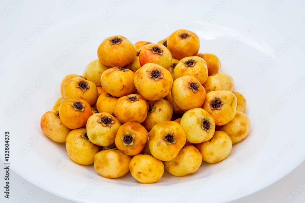 many yellow hawthorn on a white plate. in studio many yellow hawthorn on a white plate. in studio