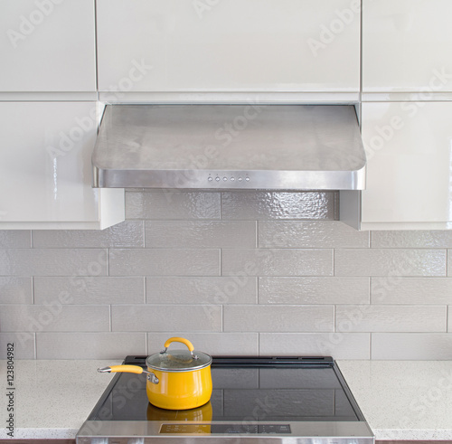Modern kitchen range with yellow cooking pot on it