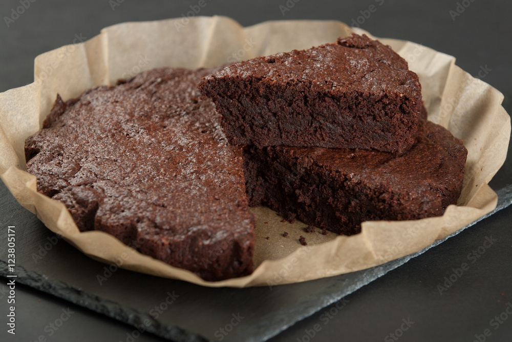 Homebaked Chocolate Brownie In Parchment Paper. Slate Stone. Homebaked Chocolate Brownie In Parchment Paper. Slate Stone.