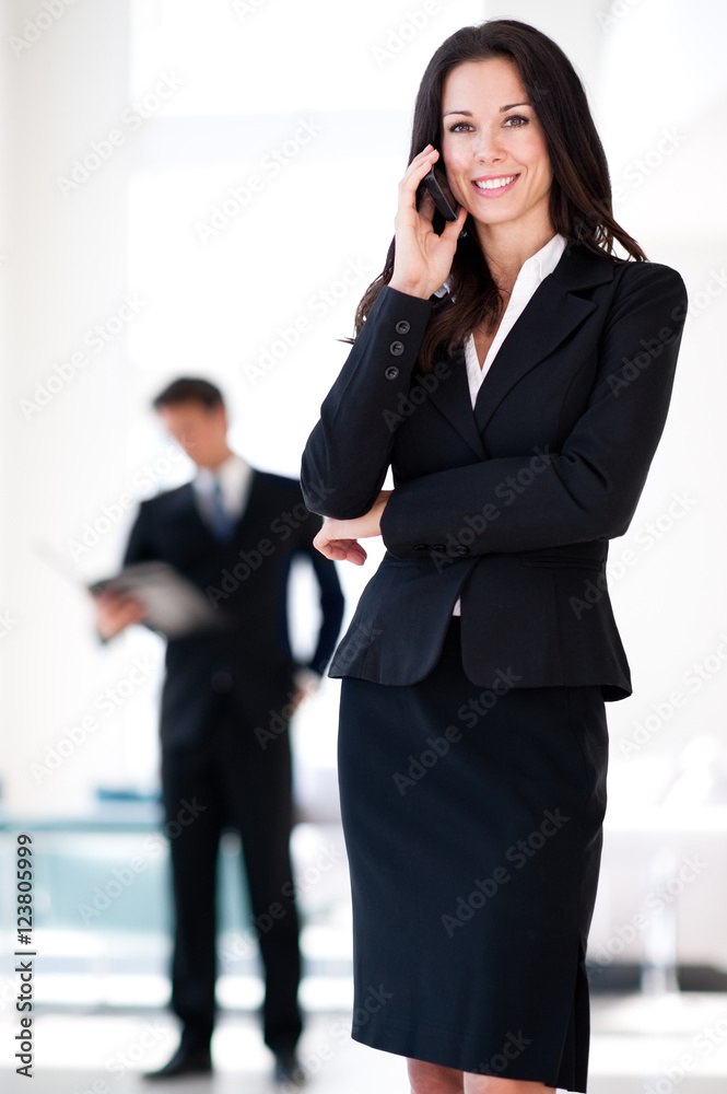 Businesswoman on mobile phone in hotel office lobby Businesswoman on mobile phone in hotel office lobby