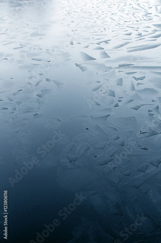 Broken water ice piece pattern floating on lake surface