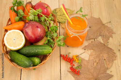 Морковный смузи в стеклянной банке с овощами на деревянном фоне. Здоровое питание.