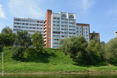 Beautiful apartment house near the river on a background of blue sky