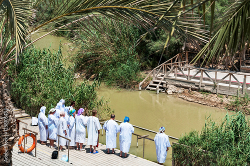 Fotografia group of pilgrims going baptize at river jordan, israel