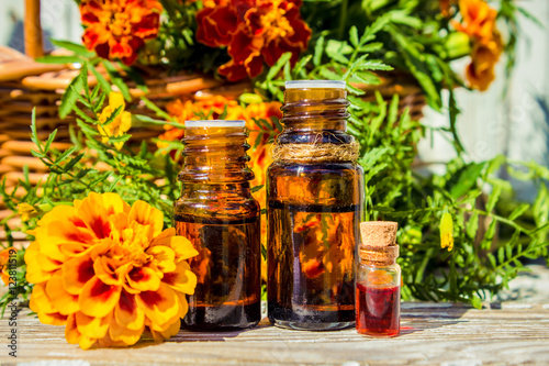 Small bottle of essential marigold oil (Tagetes flowers extract, tincture, infusion).  photo