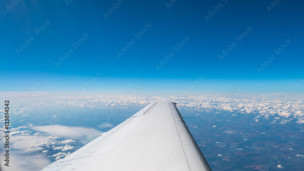 The aircraft wing on the background of picturesque cloud. Wide angle