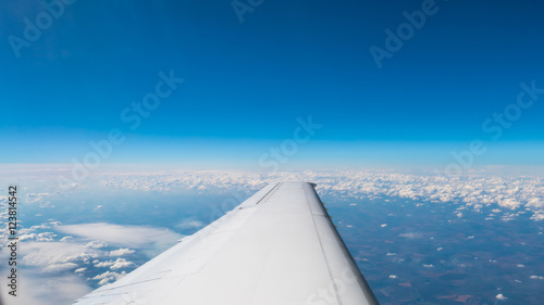 The aircraft wing on the background of picturesque cloud. Wide angle