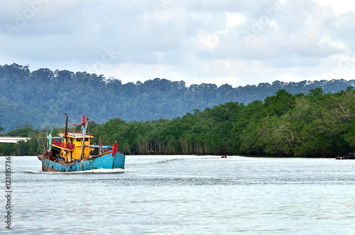 An old, rusty fishing trawler returning to harbor