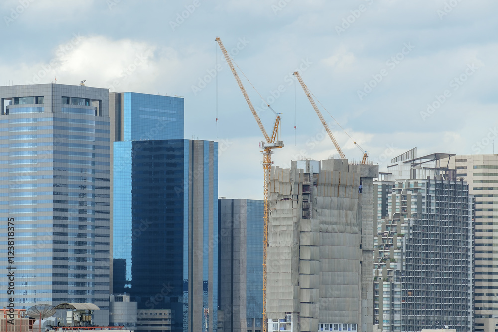 Construction / View of construction site on city background. Focus on building under construction.
