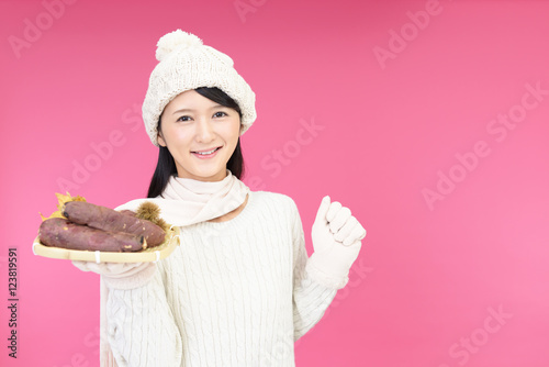 焼き芋を持つ笑顔の女性