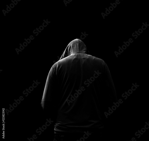 Fotografía Black and white Silhouette of a hooded man, who turned away, isolated on black b