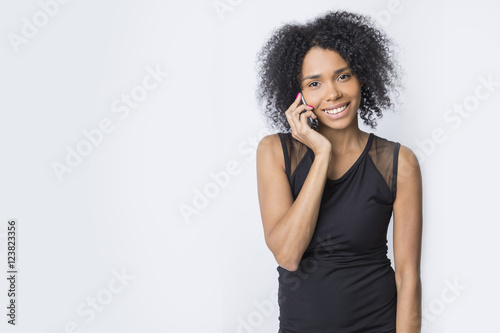Gorgeous African girl is talking on her mobile phone © ImageFlow
