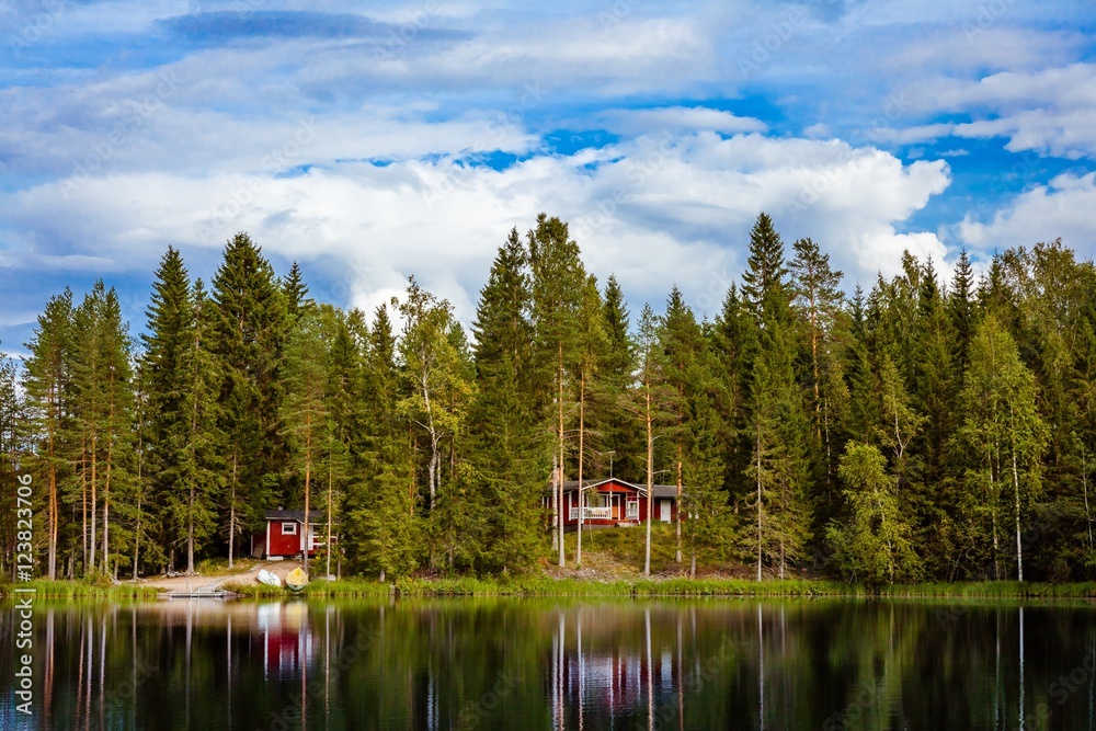 Fototapeta premium Red wooden cottage by the lake