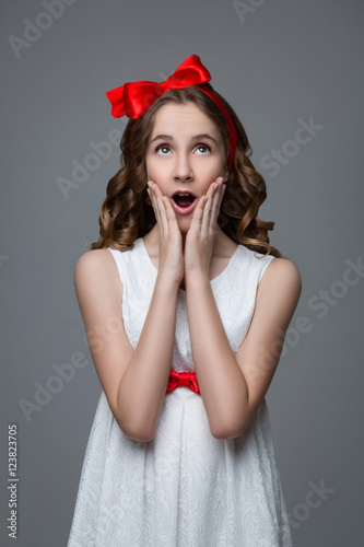 Surprised teen girl with red bow on head