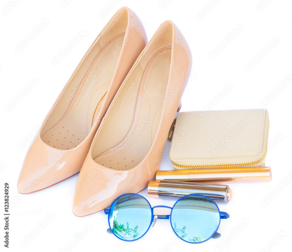 Nude colored high heels still life with wallet, sun glasses and lipstick isolated on white background Nude colored high heels still life with wallet, sun glasses and lipstick isolated on white background
