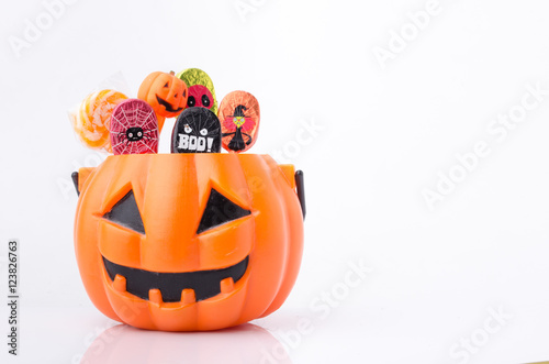 Orange pumpkin with colorful candies for Halloween party
