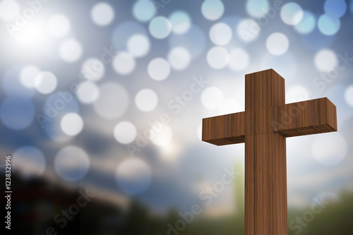 3D rendering of wooden cross on a blue sky with sunlight and bok