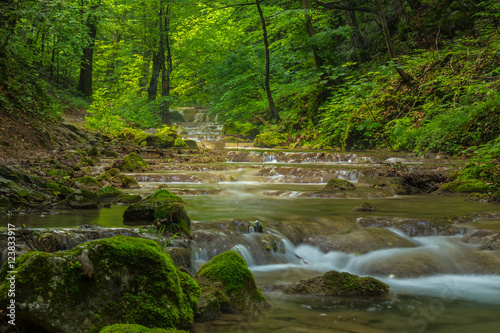 Pristine waterfalls deep in the woods  on a bright sunny day in spring