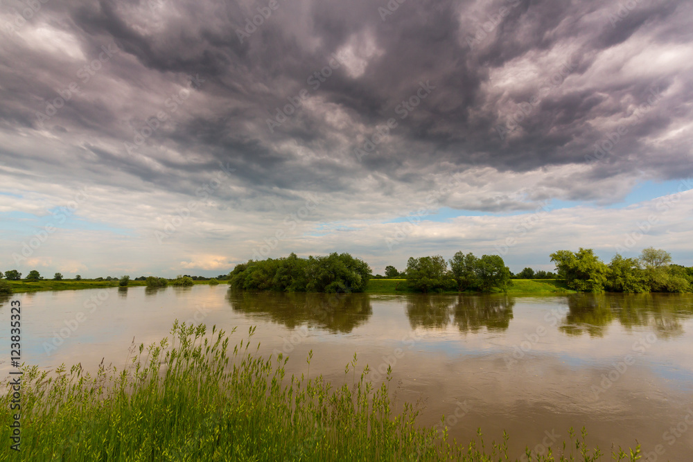 Ominous stormy sky over natural flooded river
