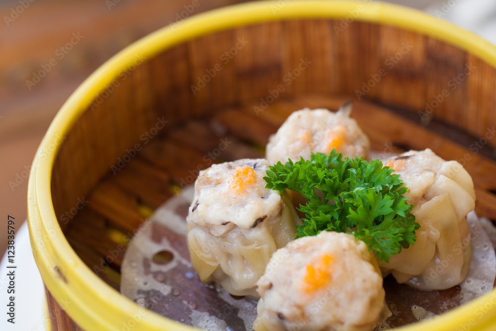 Chinese steamed dumpling or Dim sum stuffed with minced pork decorated in bamboo made steamer local style.