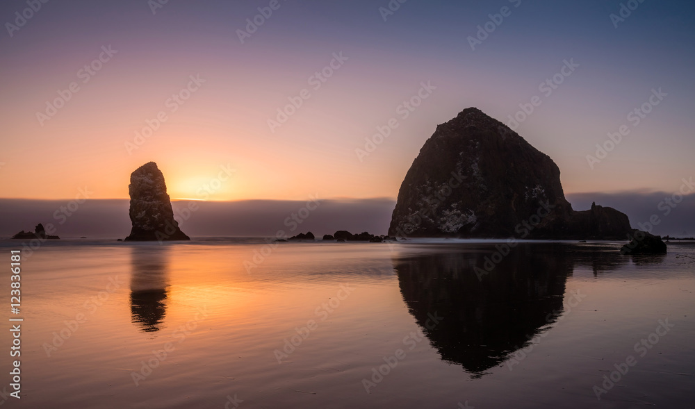 Pacific Coast Sea Stack. Silhouette of sea stacks at sunset with the famous haystack rock at Cannon beach on the Pacific Northwest coastline, Oregon