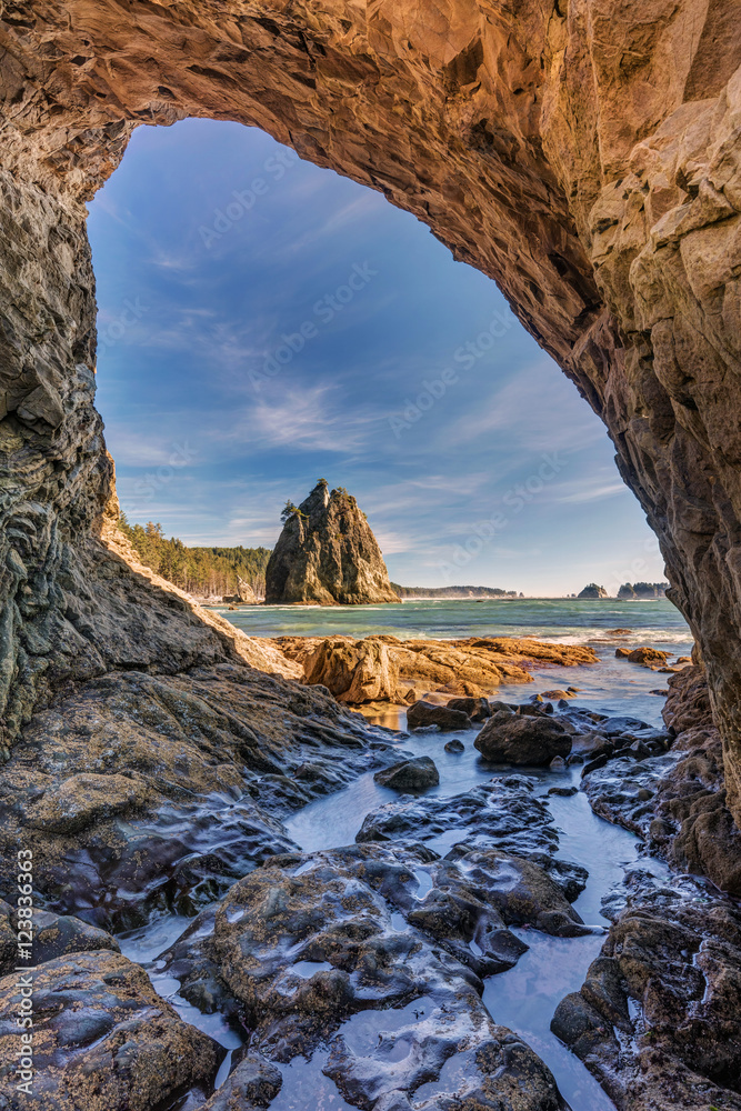 Hole in the wall at Rialto Beach, looking through a Sea Arch with a view on sea stacks on the shore of rialto beach, Olympic National Park