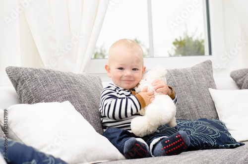 Kleiner Junge kuschelt mit seinem Teddy photo