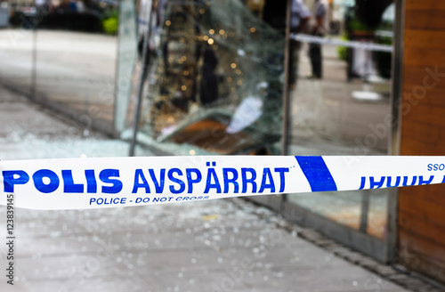 Sodertalje, Sweden - 4 August 2016: Crime scene investigation police do not cross boundary tape investigating police team, a store has been burglaries