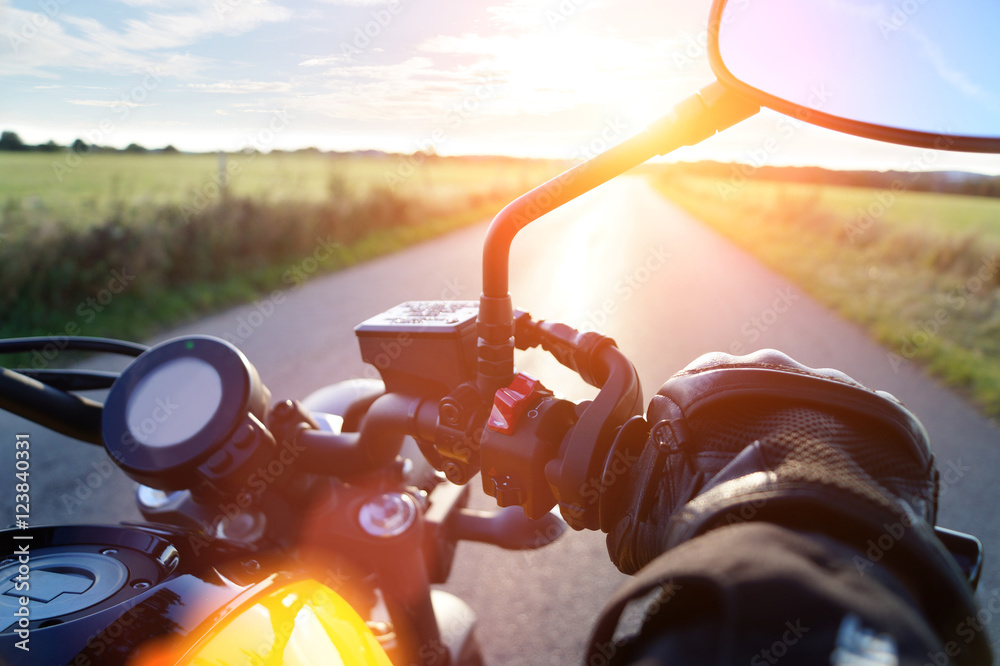 Naklejka premium Motocykl przejażdżka na autostradzie w zmierzchu przy niebieskim niebem