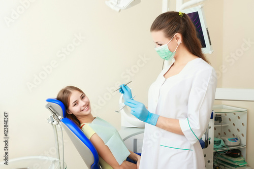 attractive woman dentist with girl patient