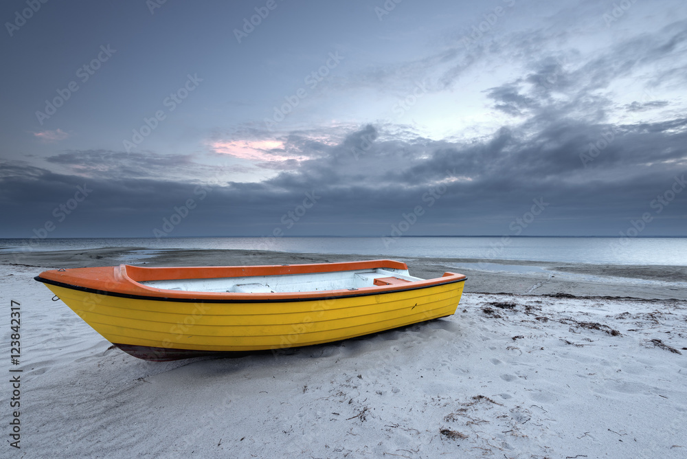 Yellow boat on the beach in cloudy day. Baltic Sea. Poland.