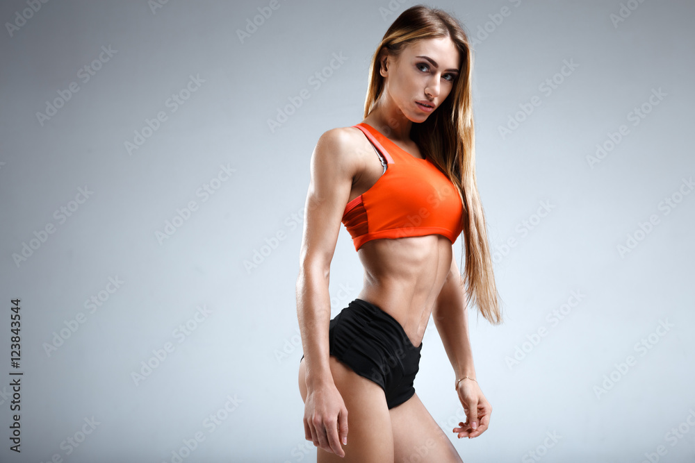 Slim female fitness model in the white studio