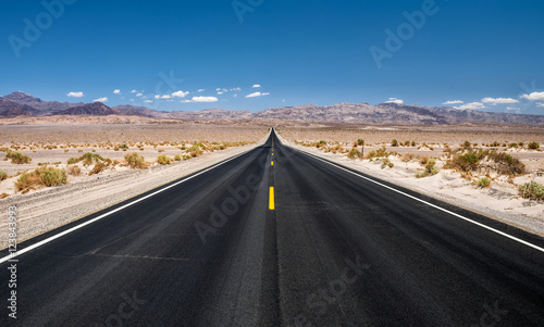Empty road running through  Death Valley National Park photo