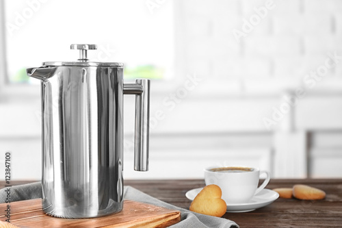 New coffee maker and cup of fresh drink with cookies on wooden table