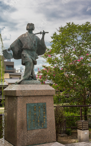 Kyoto, Japan - September 16, 2016: Izumo No Okuni statue at crossing of river and Gion neighborhood. She is the founder of the Kabuki dance at the start of 17th century. photo
