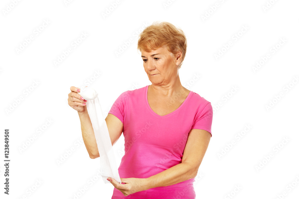 Serious senior woman holding bandage Serious senior woman holding bandage