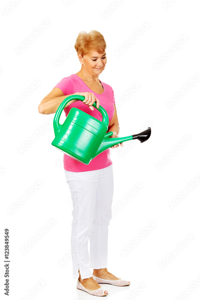 Smiling senior woman with green watering can Smiling senior woman with green watering can