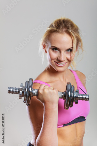 Fit woman lifting dumbbells weights