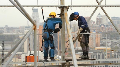 Industrial Climber Works at a Height of Weld Design.