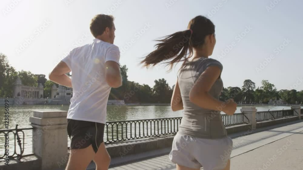 Runners jogging running in Madrid El Retiro city park. Exercising woman and man runner training on jog living healthy lifestyle in Buen Retiro Park, Parque el Retiro in Madrid, Spain, Europe.