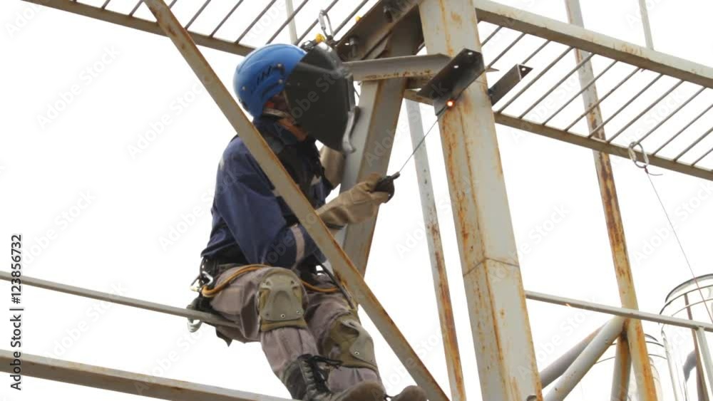 Industrial Climber Works at a Height of Weld Design. Industrial Climber Works at a Height of Weld Design.