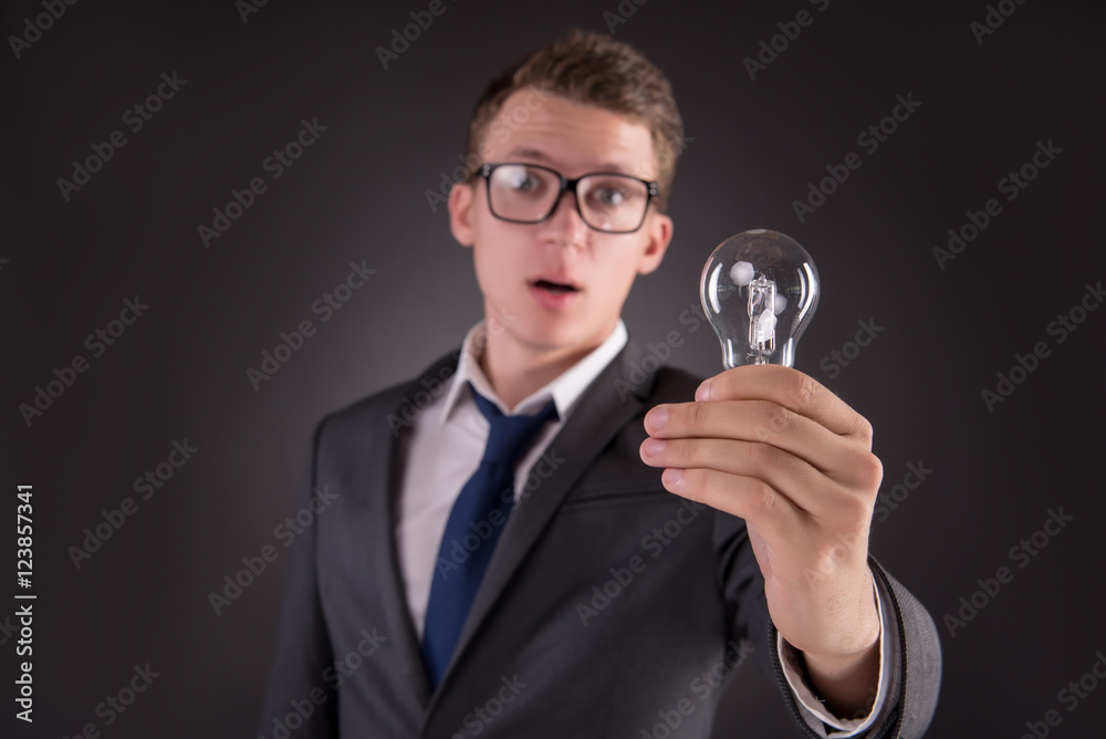 Young businessman with light bulb in idea concept Young businessman with light bulb in idea concept