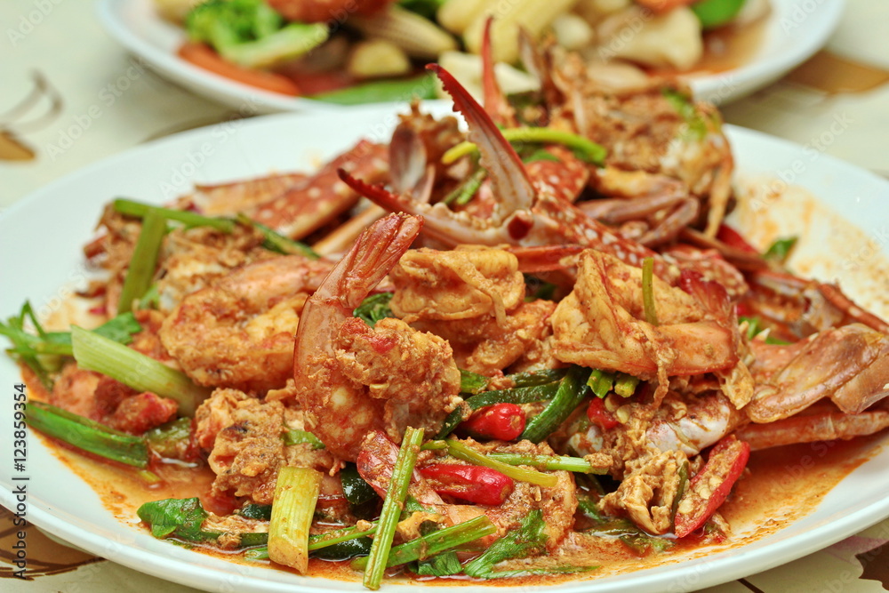 Close up of stir-fried crab and shrimp in curry power is top-ten of popular Thai food as seafood to fried with fresh milk ,grill curry ,egg ,oyster oil and yellow curry power. Selective focus. Close up of stir-fried crab and shrimp in curry power is top-ten of popular Thai food as seafood to fried with fresh milk ,grill curry ,egg ,oyster oil and yellow curry power. Selective focus.