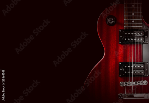 Part of the red electric guitar on black background. A place for writing of the text.