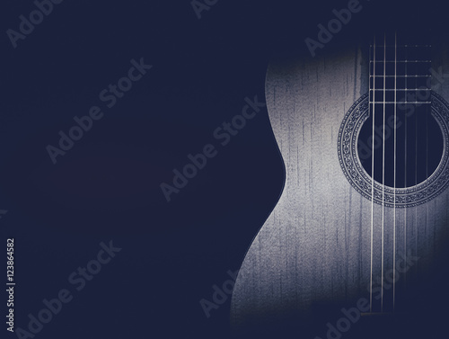 Part of a blue acoustic guitar on black background.