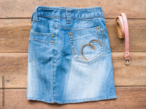 Skirt jean with pink belt on wood background
