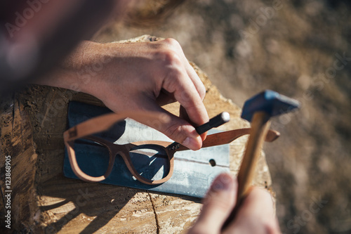 Crafting wooden sunglasses with hammer photo