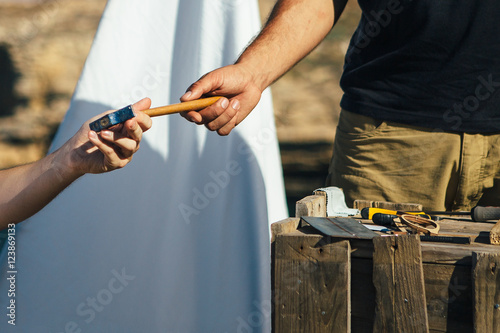 Master takes hammer form hands of another man