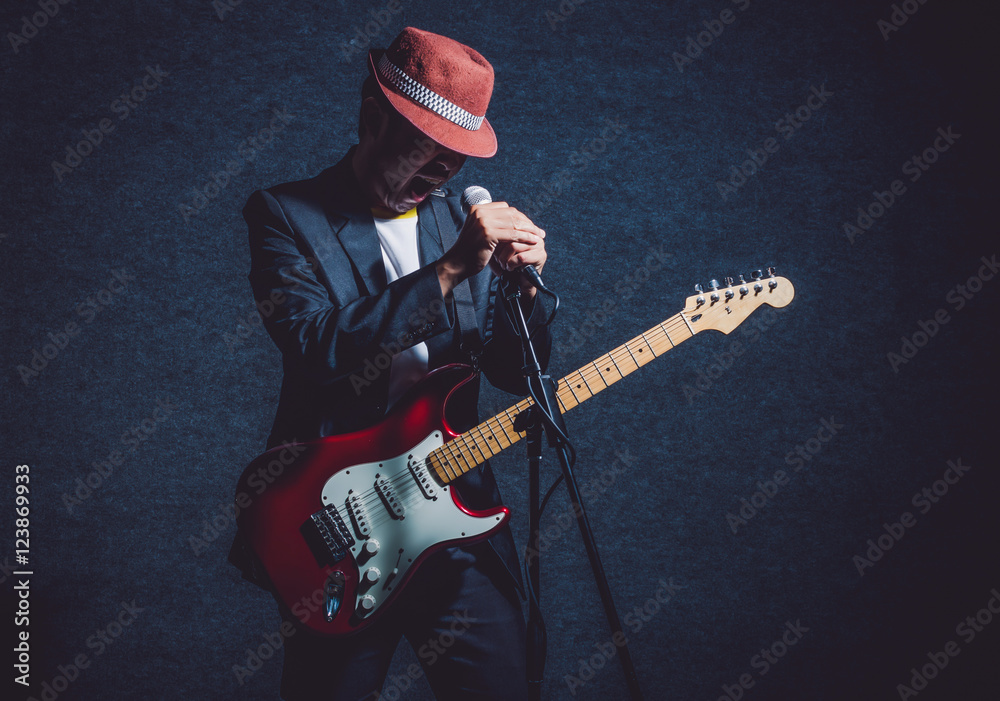 Musician playing the guitar with hand holding the microphone and Musician playing the guitar with hand holding the microphone and
