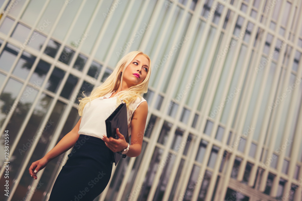 Young attractive blonde business woman over modern background